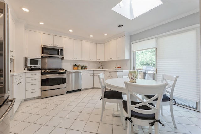 28 Verona Ct, New City, NY 10956 - kitchen featuring crown molding, light countertops, white cabinets, a sink, and appliances with stainless steel finishes