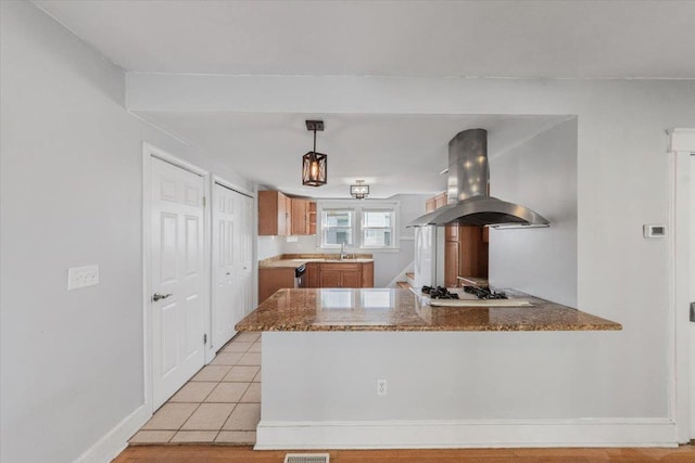 118 N Regent St, Port Chester, NY 10573 - kitchen with island range hood, light tile patterned floors, white gas cooktop, a sink, and a peninsula
