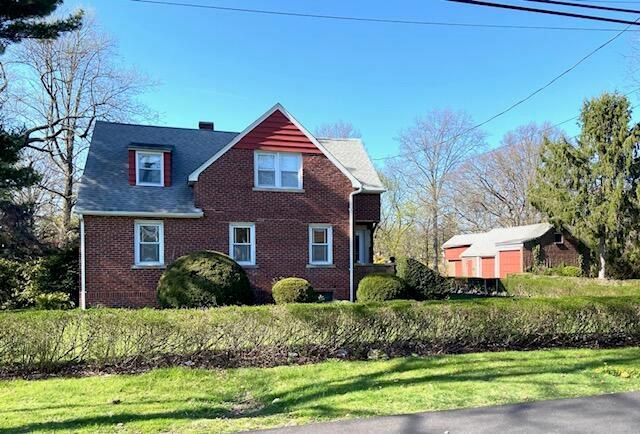 view of front of property featuring a front lawn and brick siding