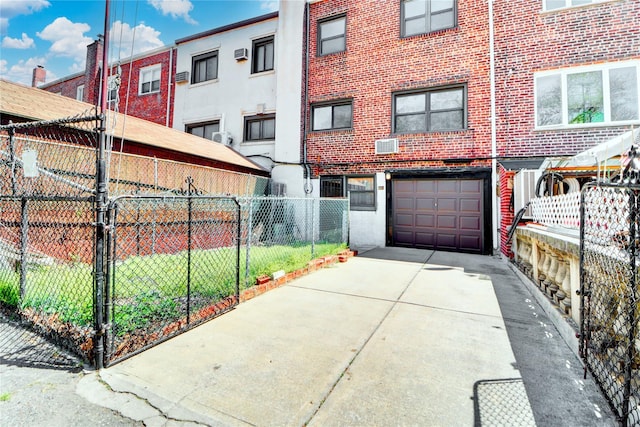 48-42 64th St, Woodside, NY 11377 - exterior space featuring fence, concrete driveway, brick siding, and an attached garage