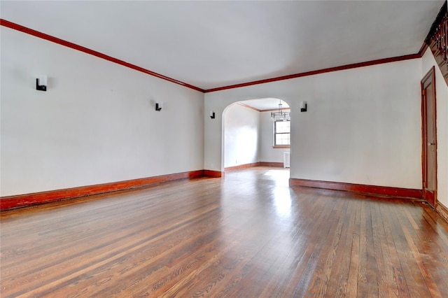48-42 64th St, Woodside, NY 11377 - empty room featuring baseboards, arched walkways, crown molding, and wood-type flooring