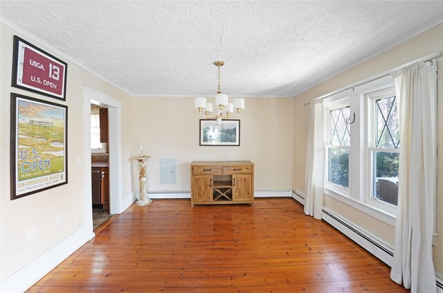 48 Watchogue Ave, East Moriches, NY 11940 - unfurnished dining area with baseboard heating, a chandelier, a textured ceiling, and hardwood / wood-style floors
