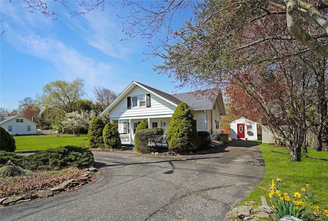 48 Watchogue Ave, East Moriches, NY 11940 - view of front of house featuring driveway, a front yard, and a porch