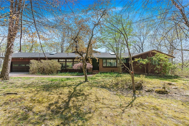 view of front of property featuring a garage, concrete driveway, and brick siding