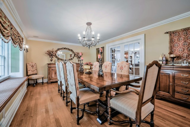 dining room featuring a chandelier, crown molding, light wood-style flooring, baseboards, and french doors