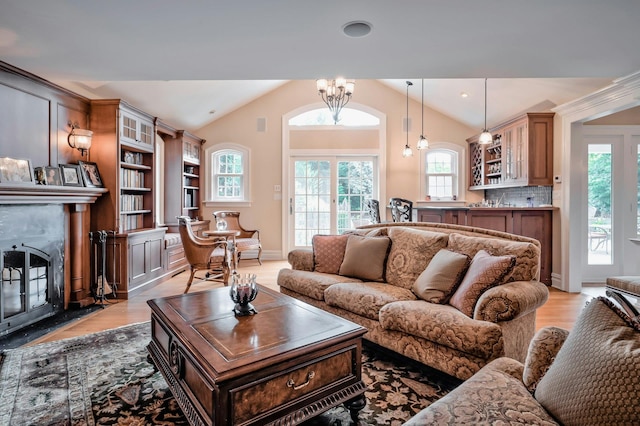 living room with a fireplace, plenty of natural light, lofted ceiling, and light wood-style floors