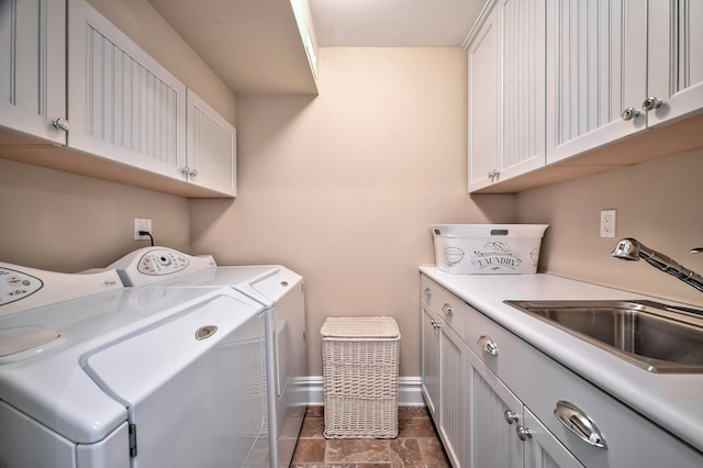 laundry area with washer and dryer, baseboards, cabinet space, and a sink