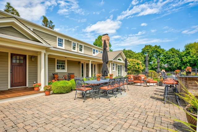 view of patio featuring outdoor dry bar, outdoor dining area, and fence