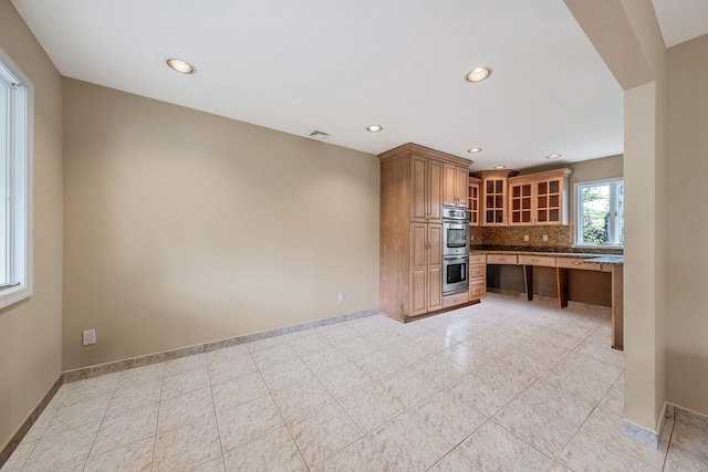 57 Seward Dr, Dix Hills, NY 11746 - kitchen featuring brown cabinetry, decorative backsplash, glass insert cabinets, baseboards, and double oven