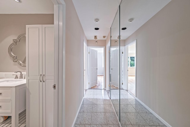 57 Seward Dr, Dix Hills, NY 11746 - hallway featuring baseboards, a sink, and light tile patterned floors