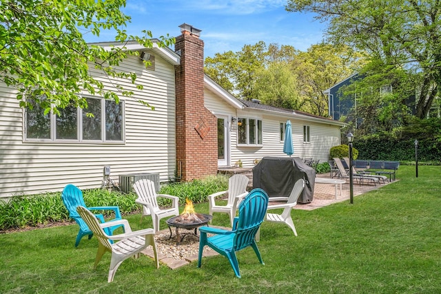 57 Seward Dr, Dix Hills, NY 11746 - back of property with a lawn, a chimney, an outdoor fire pit, and a patio area