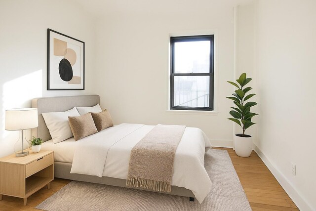 21-58 35th St Unit 5G, Astoria, NY 11105 - bedroom with light wood-style floors and baseboards