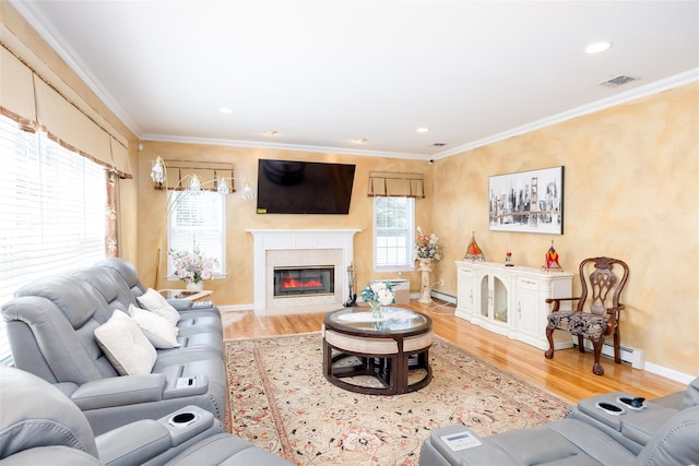 living area with crown molding, visible vents, and wood finished floors