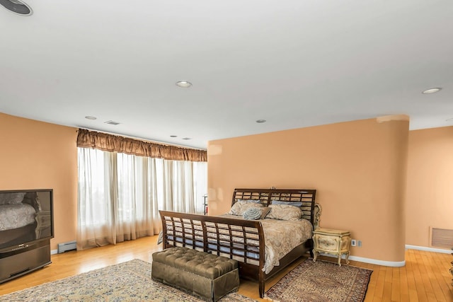 9 Dock Ln, Kings Point, NY 11024 - bedroom with wood-type flooring, baseboards, recessed lighting, and baseboard heating