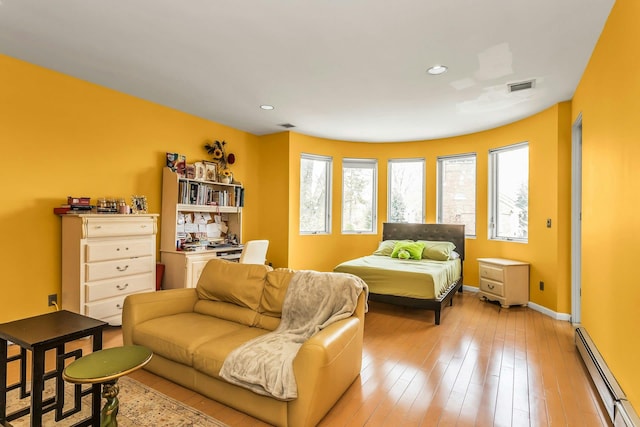 9 Dock Ln, Kings Point, NY 11024 - bedroom with baseboard heating, multiple windows, baseboards, recessed lighting, and light wood finished floors