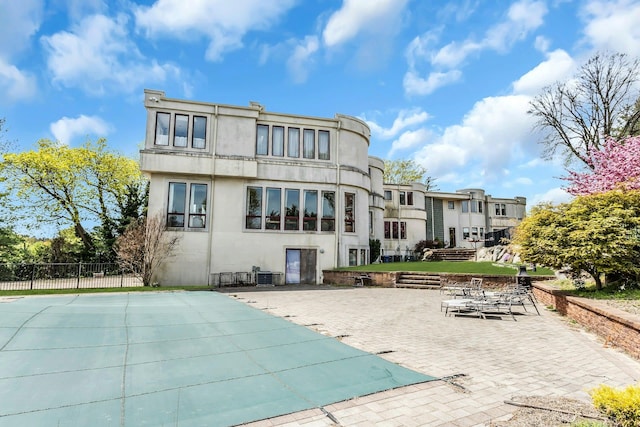 9 Dock Ln, Kings Point, NY 11024 - rear view of house featuring stucco siding, a patio area, and a residential view