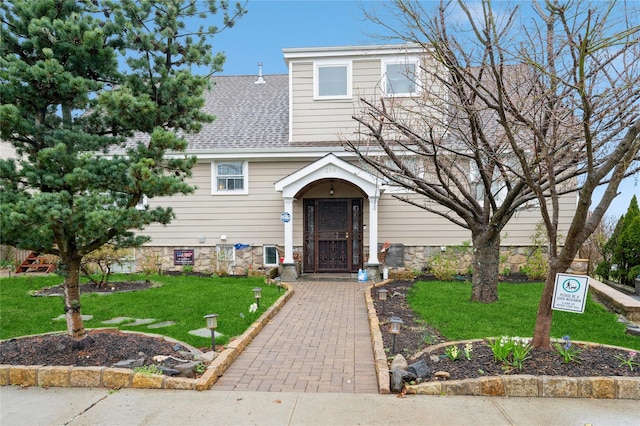 258 Longstreet Ave, Bronx, NY 10465 - view of front of home with a front yard, a shingled roof, and stone siding