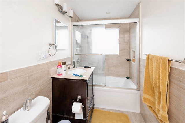 258 Longstreet Ave, Bronx, NY 10465 - full bath featuring bath / shower combo with glass door, a wainscoted wall, toilet, tile walls, and vanity