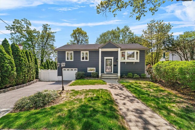 raised ranch with asphalt driveway and a garage