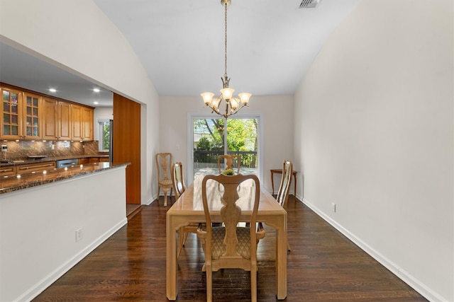 dining room featuring vaulted ceiling, a chandelier, dark wood finished floors, and baseboards