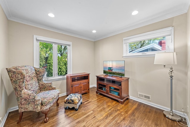 living area with plenty of natural light, wood finished floors, ornamental molding, baseboards, and recessed lighting