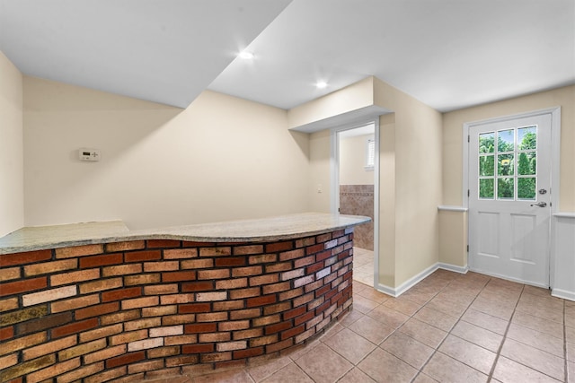 foyer entrance featuring light tile patterned floors, baseboards, a dry bar, and recessed lighting