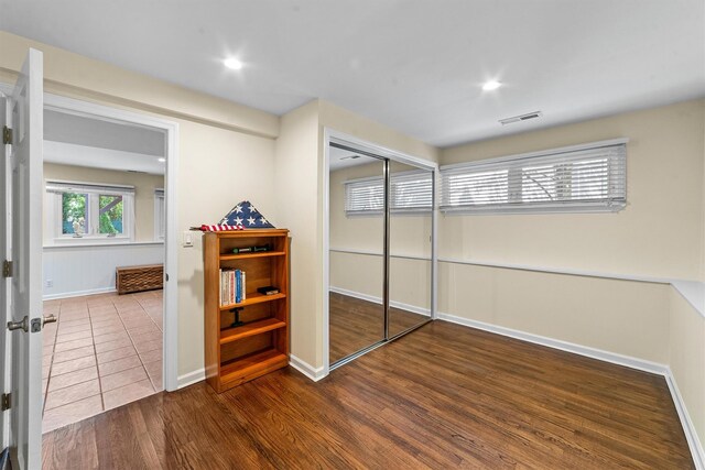 bedroom with baseboards, a closet, wood finished floors, and recessed lighting