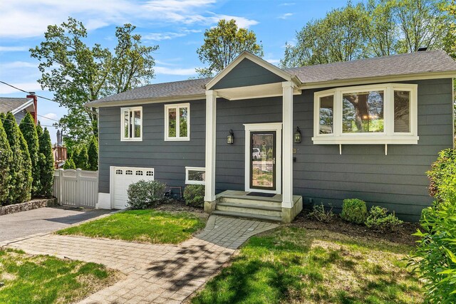 bi-level home featuring asphalt driveway and a garage
