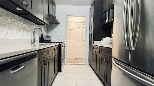 40 Stoner Ave Unit 1S, Great Neck, NY 11021 - kitchen featuring appliances with stainless steel finishes, tasteful backsplash, a sink, under cabinet range hood, and light tile patterned flooring