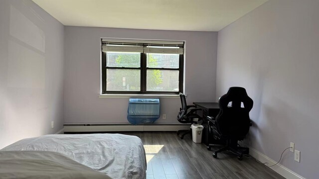 40 Stoner Ave Unit 1S, Great Neck, NY 11021 - bedroom with baseboards, a baseboard heating unit, and wood finished floors