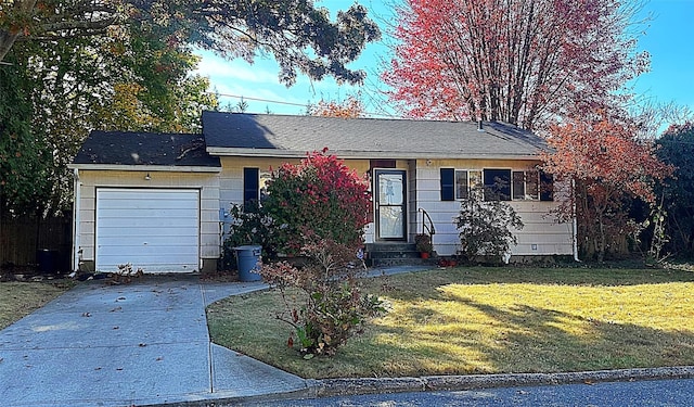 ranch-style home featuring a garage, entry steps, driveway, and a front lawn