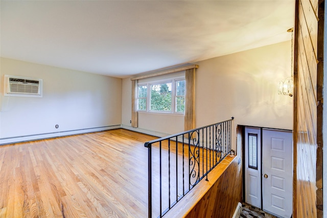 stairway featuring wood finished floors, baseboards, an AC wall unit, a baseboard heating unit, and a notable chandelier
