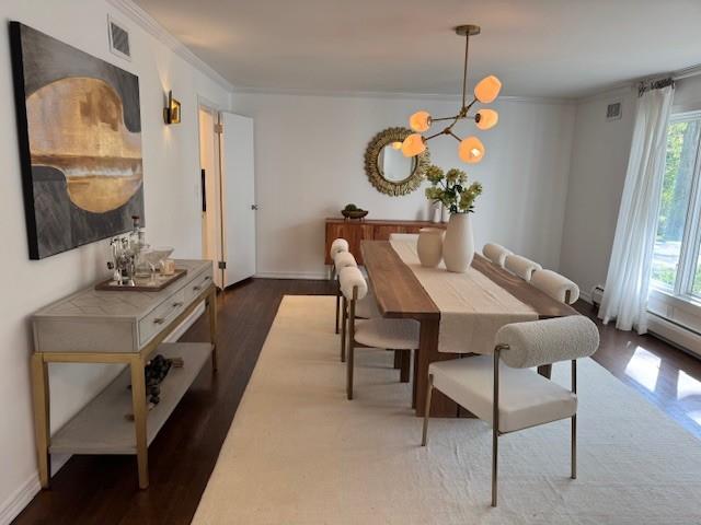 dining area featuring an inviting chandelier, crown molding, visible vents, wood finished floors, and baseboards