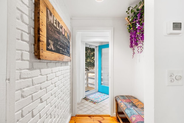 entryway featuring ornamental molding and light wood-style floors