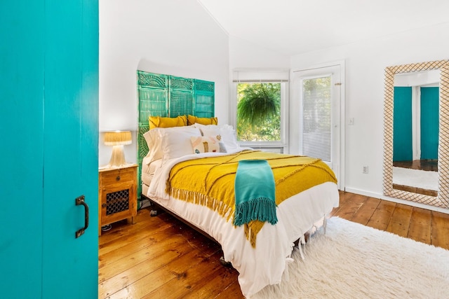 bedroom featuring lofted ceiling and hardwood / wood-style flooring