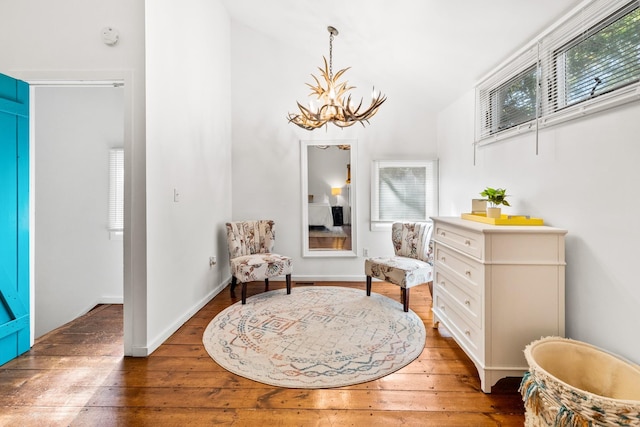 living area with an inviting chandelier, hardwood / wood-style floors, and plenty of natural light