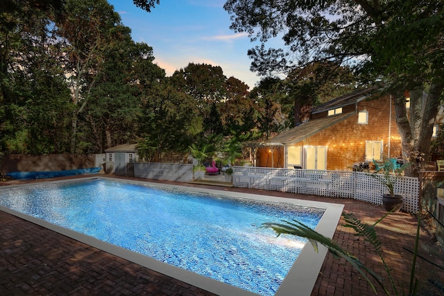 pool with fence and a patio