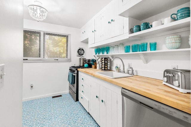 kitchen featuring wood counters, open shelves, appliances with stainless steel finishes, white cabinets, and a sink
