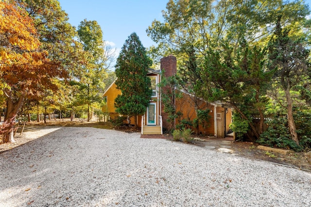 view of front facade featuring fence, a chimney, and entry steps