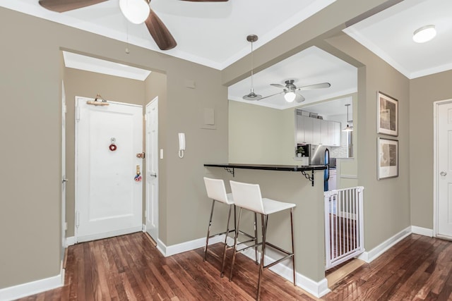 entrance foyer with baseboards, ornamental molding, ceiling fan, and dark wood-style floors