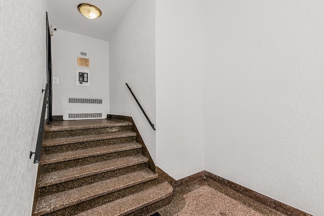 stairs featuring a textured wall
