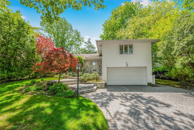 96 Mulberry Ave, Garden City, NY 11530 - tri-level home featuring an attached garage, a front yard, and decorative driveway