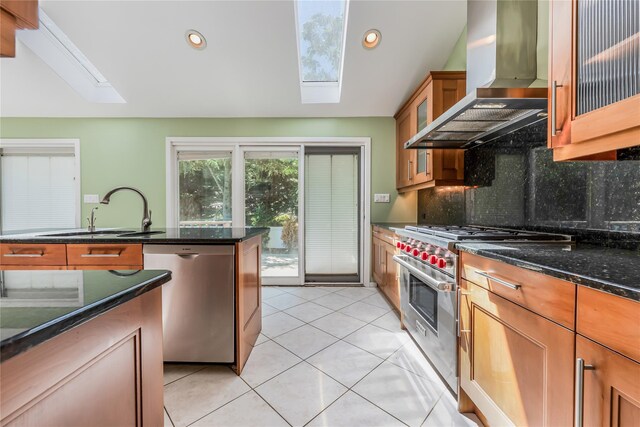 96 Mulberry Ave, Garden City, NY 11530 - kitchen featuring appliances with stainless steel finishes, a skylight, wall chimney range hood, decorative backsplash, and a sink