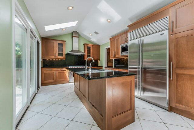 96 Mulberry Ave, Garden City, NY 11530 - kitchen with built in appliances, wall chimney exhaust hood, a skylight, lofted ceiling, and decorative backsplash