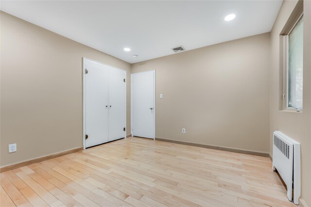 96 Mulberry Ave, Garden City, NY 11530 - empty room with radiator heating unit, light wood-style floors, baseboards, and recessed lighting