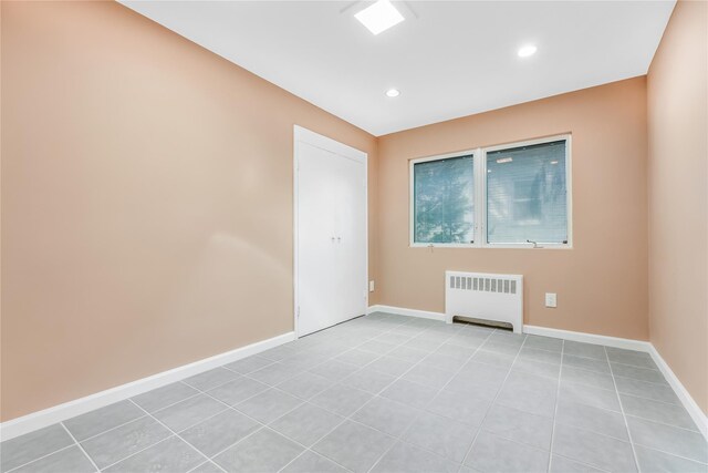 96 Mulberry Ave, Garden City, NY 11530 - empty room with radiator, baseboards, recessed lighting, and light tile patterned floors