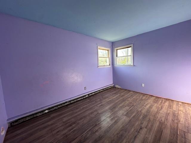 spare room with baseboard heating and wood finished floors