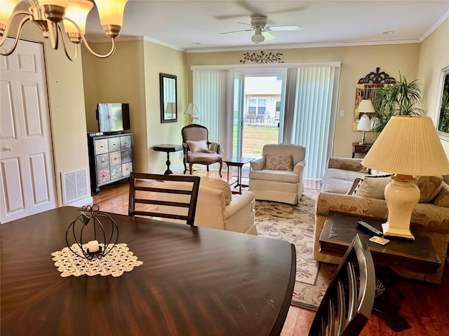 living room featuring visible vents, baseboards, ornamental molding, wood finished floors, and ceiling fan with notable chandelier