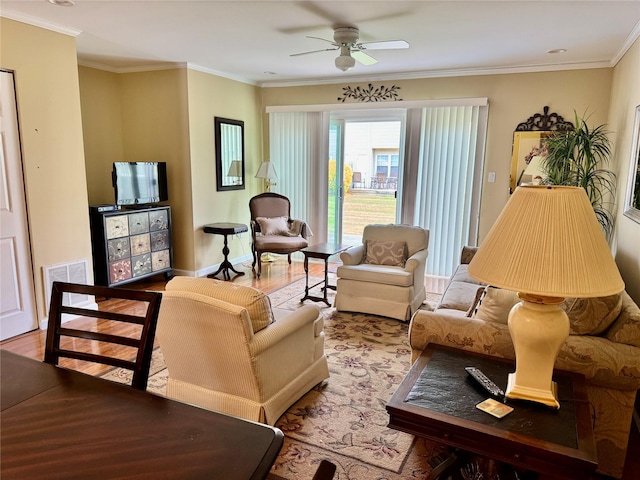 living room featuring wood finished floors, a ceiling fan, and ornamental molding