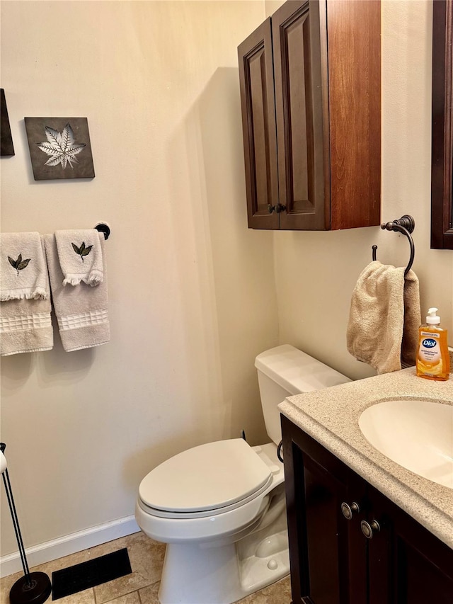 half bath with vanity, toilet, and baseboards
